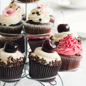 chocolate cupcake with white frosting and cherries