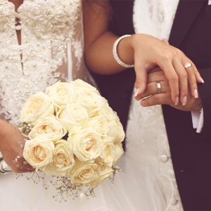 bride and groom holding hands with their rings showing