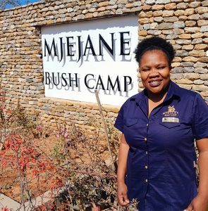 lady standing before mjejane game reserve sign
