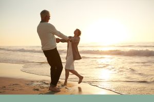 older couple dancing on the beach